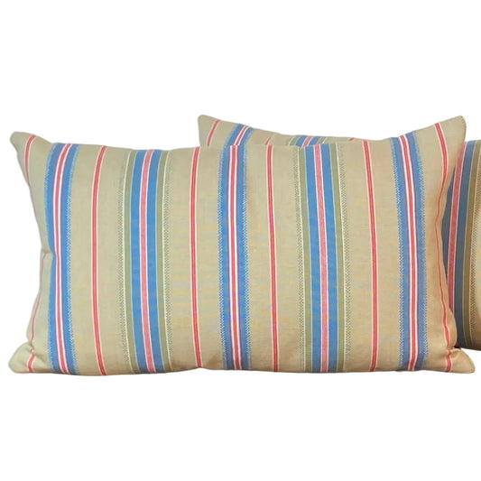 Striped lumbar cushion with a green neutral background blue red and white stripes.